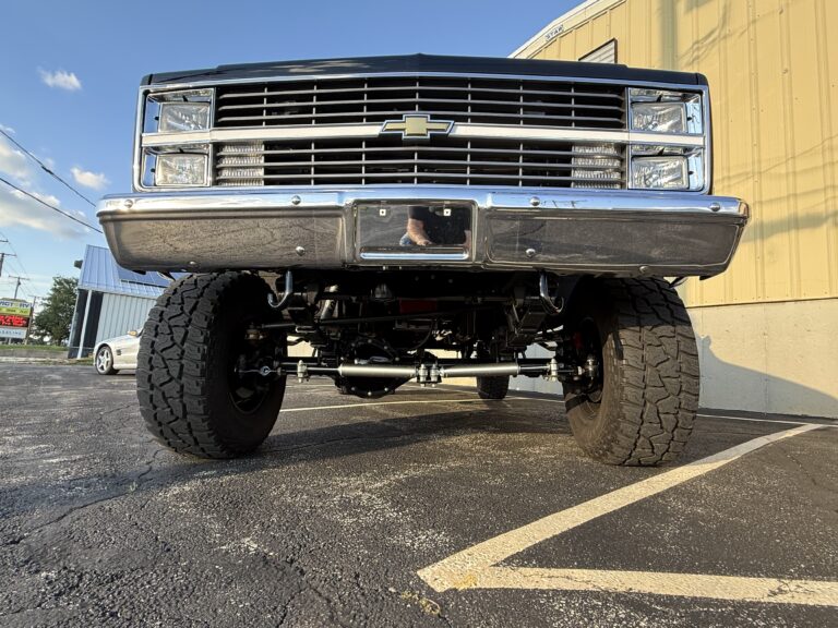 1983 Chevrolet K20 Silverado 4x4, low front view showing the lifted front axle and steering linkage